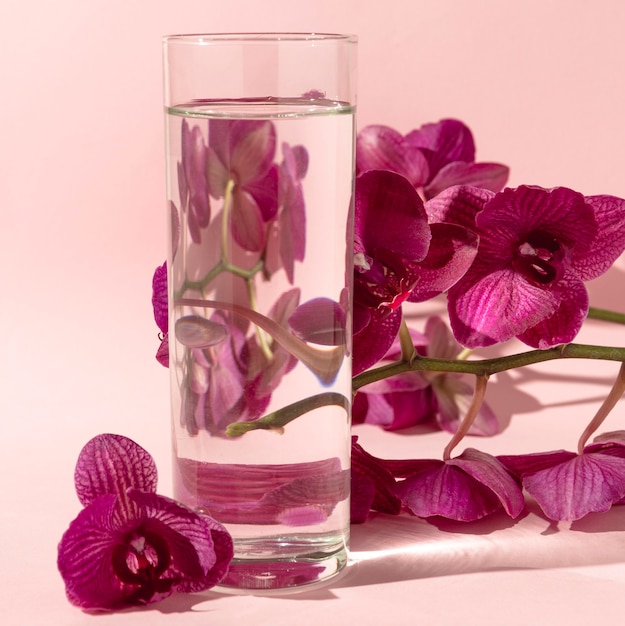 Glas met water naast bloemen