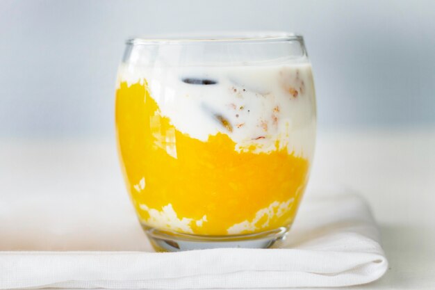 Glas met yoghurt op een stuk doek