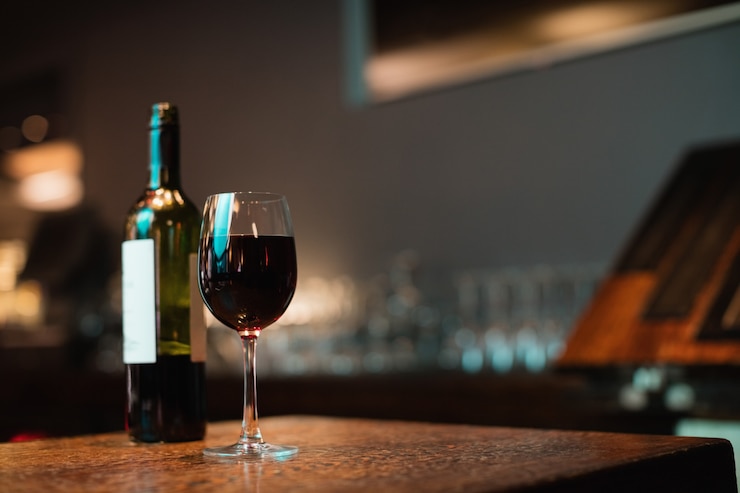 Gratis Foto glas rode wijn en fles op toog