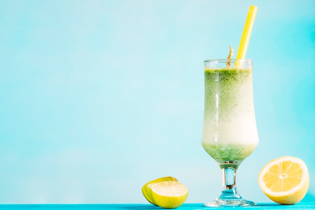 Glas romige groene smoothie en gesneden citrusvruchten