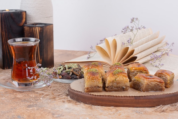 Glas thee en traditionele verschillende baklava's op marmeren tafel.