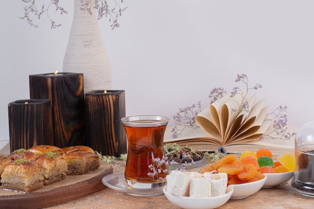 Glas thee, snoep en traditionele verschillende baklava's op marmeren tafel.