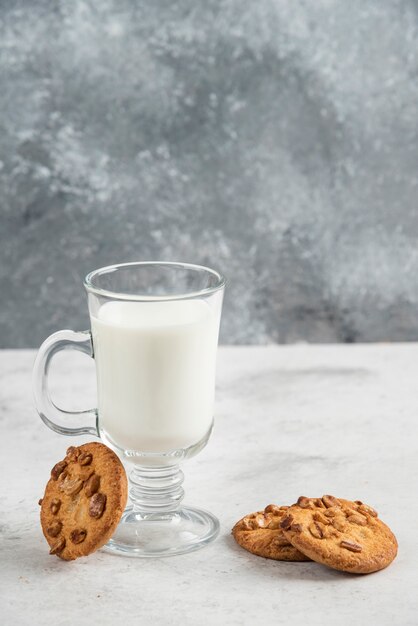 Glas verse melk en lekkere koekjes op marmeren tafel.