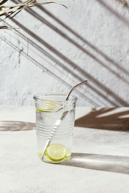 Gratis foto glas water met schijfjes citroen op tafel