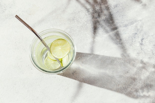 Gratis foto glas water met schijfjes citroen op tafel