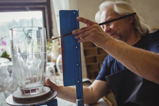 Glasblazer die aan een glaswerk werkt