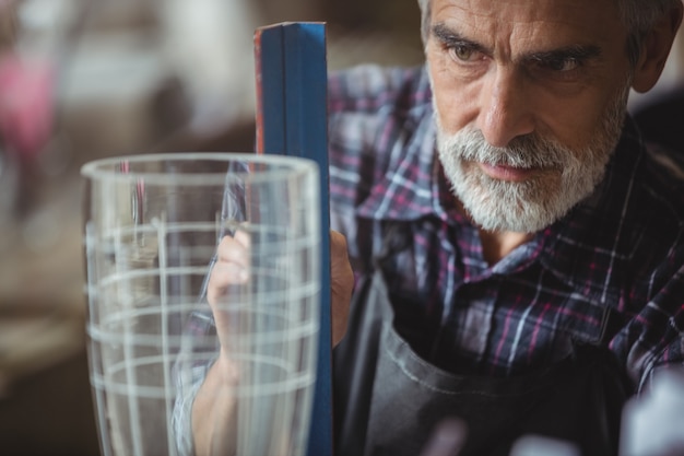 Gratis foto glasblazer die aan een glaswerk werkt