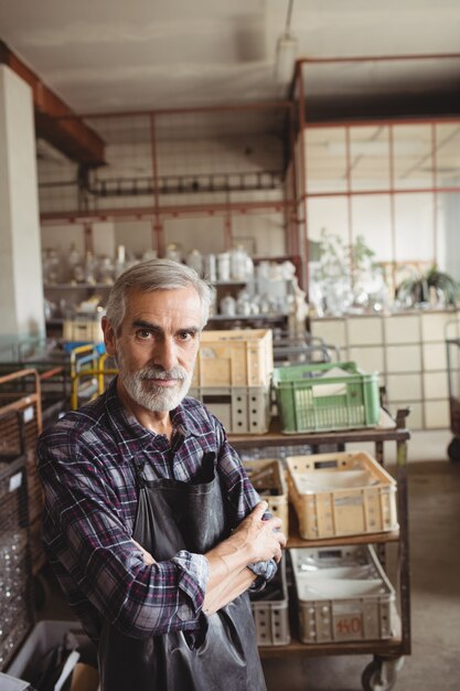 Glasblazer die zich met wapens bevinden die bij glasblazende fabriek worden gekruist