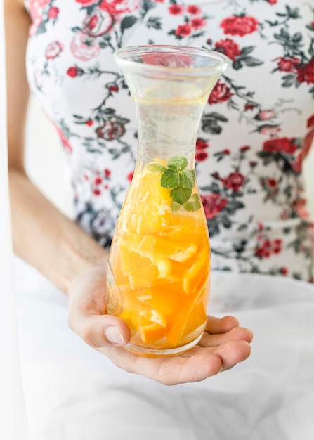 Glazen container gevuld met sinaasappel en water
