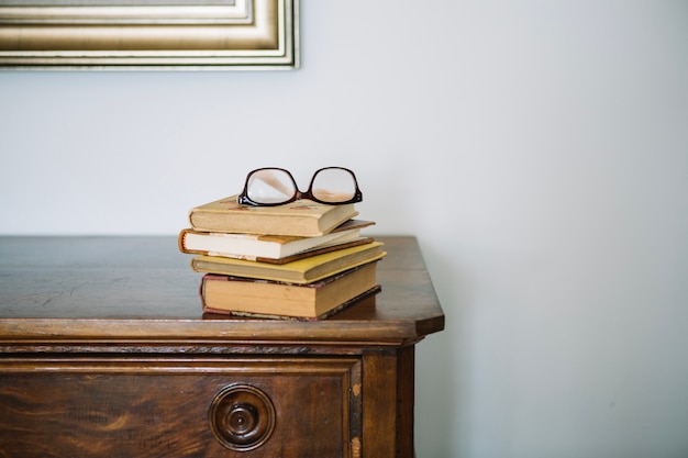 Gratis foto glazen die op stapel van oude boeken liggen