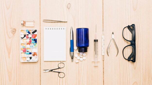 Glazen en een notebook in de buurt van medicijnen