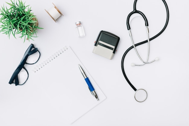 Glazen en een notebook in de buurt van medische benodigdheden