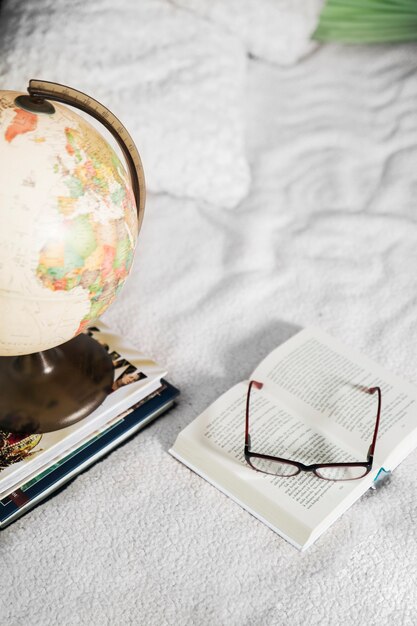 Glazen en globe in de buurt van boeken