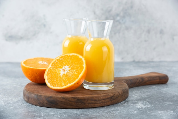Glazen kruiken sap met schijfje sinaasappelfruit.