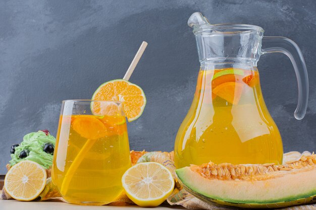 Glazen limonades met plakjes citroen op blauwe muur.