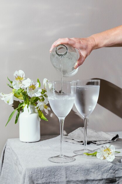 Glazen water en bloemen op tafel
