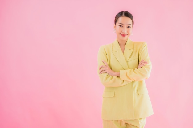 Glimlach van de portret de mooie jonge Aziatische bedrijfsvrouw in actie op roze kleur