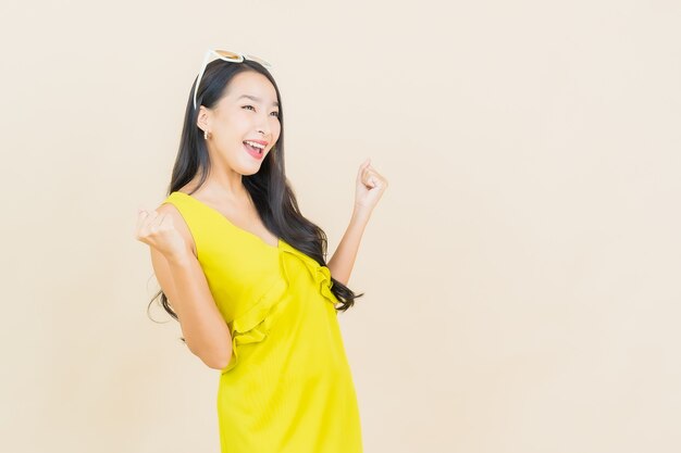 Glimlach van de portret de mooie jonge Aziatische vrouw met actie op roommuur