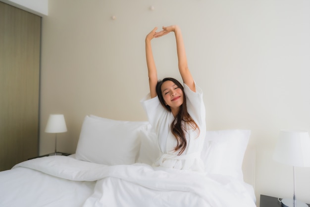 Glimlachen de portret mooie jonge Aziatische vrouwen gelukkig op bed