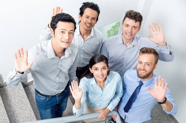 Glimlachend Business Team Waving On Office Trap