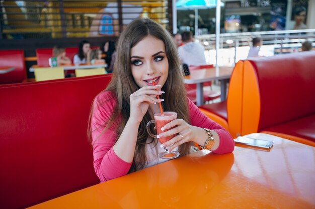 Glimlachend jonge vrouw het drinken van een frisdrank
