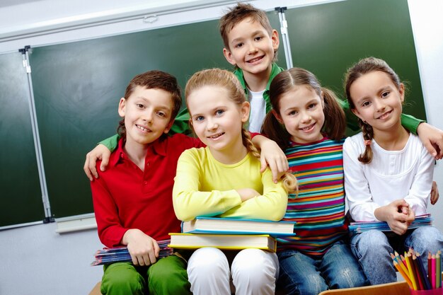 Glimlachend kind knuffelen zijn klasgenoten