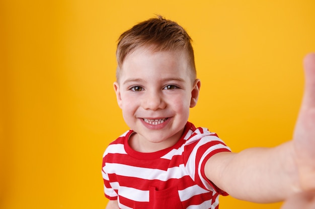 Glimlachend kleine mobiele telefoon houden en jongen die selfie maken