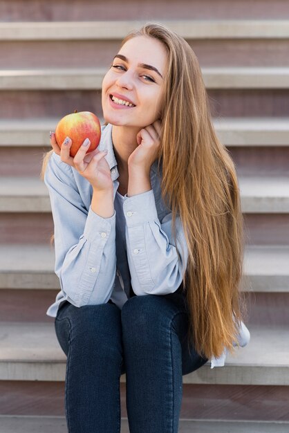 Glimlachend meisje dat een heerlijke appel houdt
