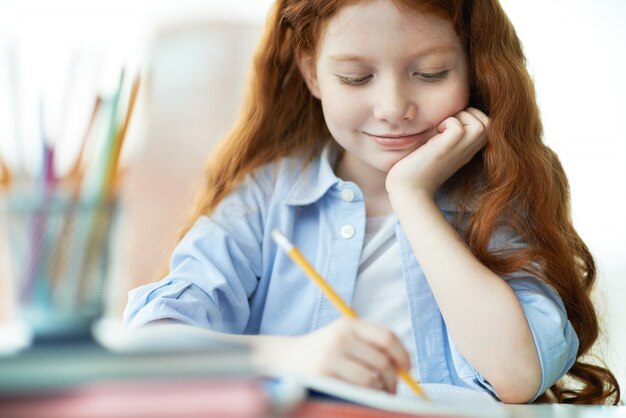 Glimlachend meisje het afronden van haar huiswerk