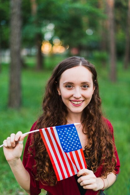 Glimlachend meisje met Amerikaanse vlag in de natuur
