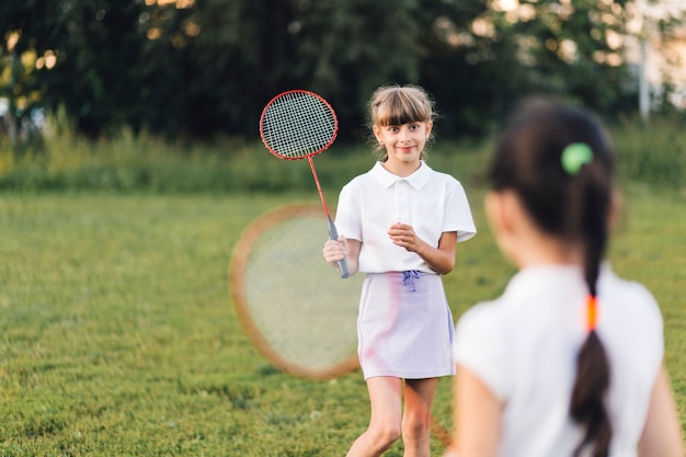 Glimlachend meisjes speelbadminton met haar vriend