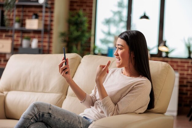 Glimlachend mooie authentieke Aziatische vrouw op online internet webtechnologie video-oproep afzien van camera, thuis vrije tijd levensstijl digitale webcommunicatie webcam chat freelacer thuis