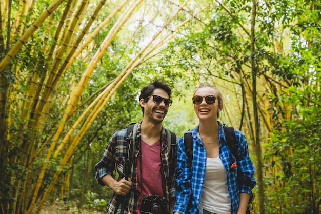 Glimlachend paar dat door bamboebos loopt
