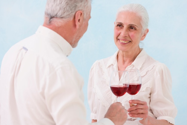 Glimlachend paar dat elkaar bekijkt terwijl rammelende wijnglas