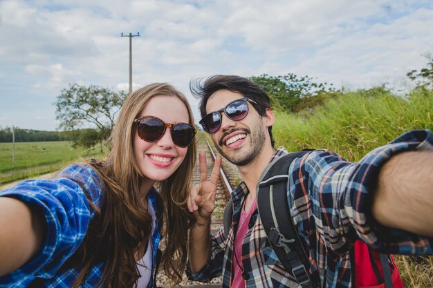 Glimlachend paar nemen een selfie op treinsporen