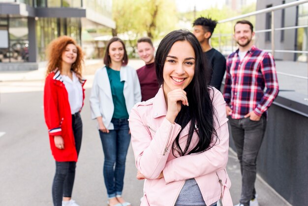 Glimlachend portret van een mooie vrouw die zich voor haar vrienden bevindt