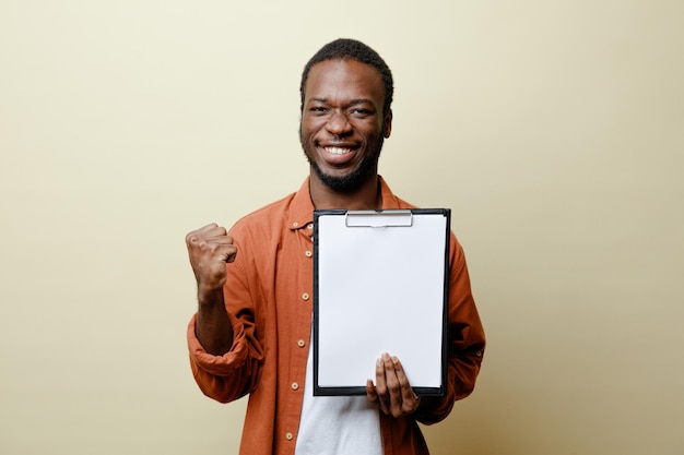 Glimlachend tonen ja gebaar jonge Afro-Amerikaanse man met klembord geïsoleerd op een witte achtergrond