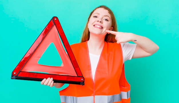 glimlachend vol vertrouwen wijzend naar eigen brede glimlach