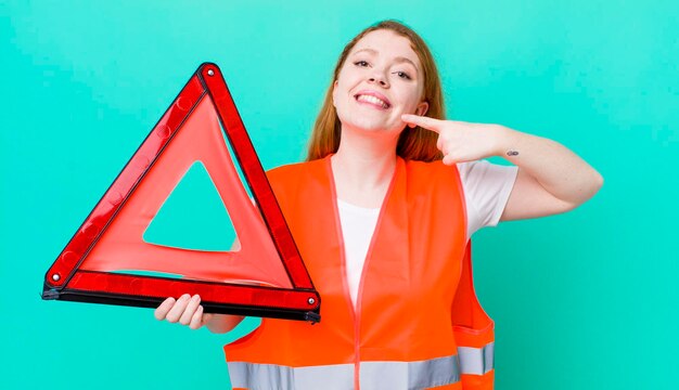 glimlachend vol vertrouwen wijzend naar eigen brede glimlach