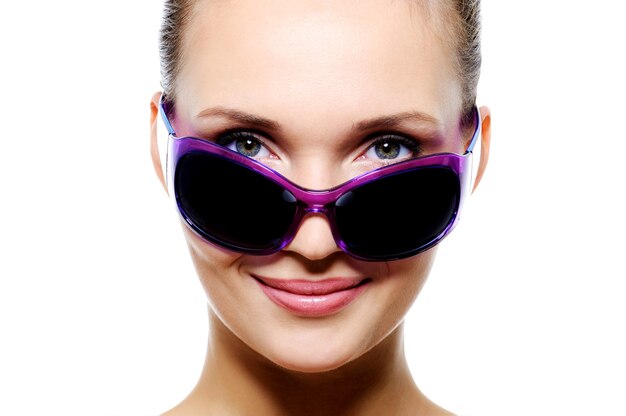 Glimlachend vrouwengezicht in donkere violette zonnebril