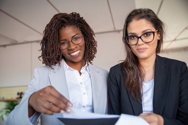 Glimlachende Afrikaanse Amerikaanse vrouwen draaiende pagina van document