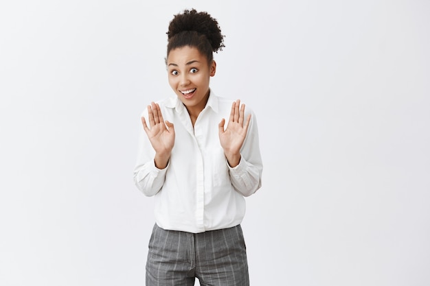 Glimlachende afro-amerikaanse vrouw handen opsteken in overgave, iets tegenhouden