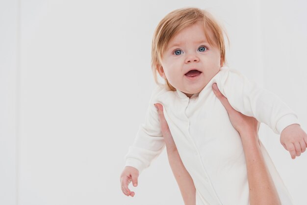 Glimlachende baby gehouden voor pose