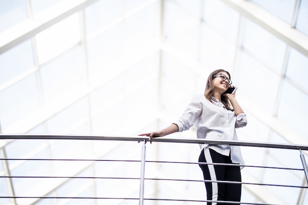 Glimlachende dame succesvolle zakelijke vrouwen staan rusten en kijken door op balkon in modern kantoor centrum gekleed in wit t-shirt