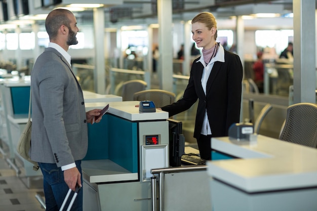 Glimlachende forens interactie met begeleider bij check-in balie