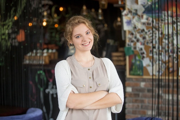 Glimlachende gelukkige zakenvrouw poseren in haar eigen koffie winkel