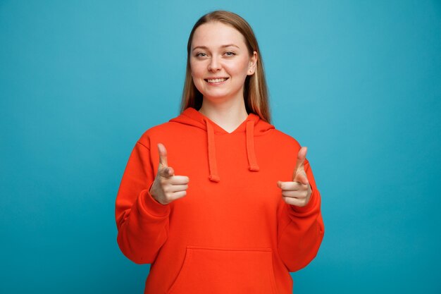 Glimlachende jonge blonde vrouw die je gebaar doet