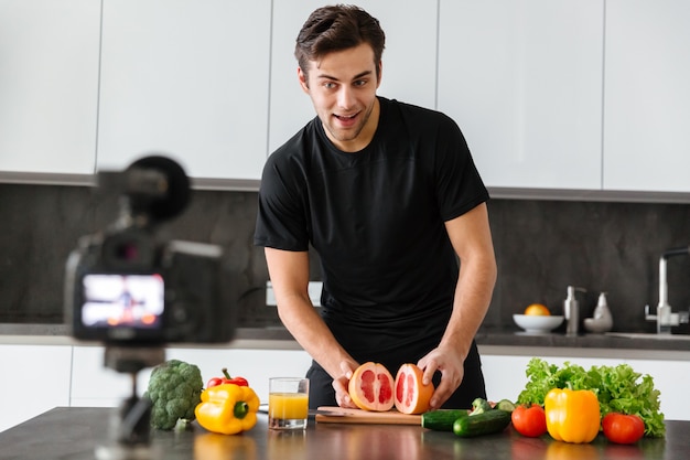 Glimlachende jonge man die zijn videoblogaflevering filmt