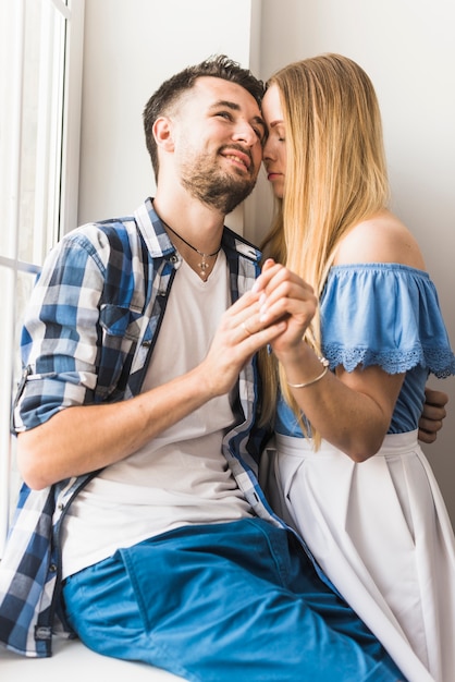 Glimlachende jonge man met zijn vriendin