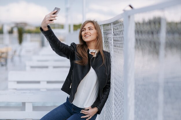 Glimlachende jonge vrouw die een foto van zichzelf